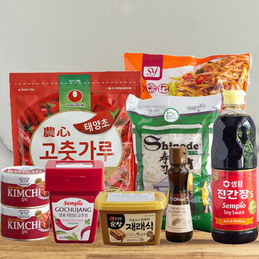 Photo du kit des indispensables de la cuisine coréenne : kimchi, gochujang, doenjang, gochugaru, riz, huile de sésame, sauce soja coréenne, nouille dangmyeon.