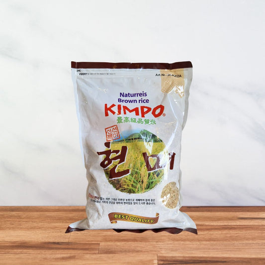sachet de riz brun à grain court kimpo avec un visuel de rizière et de tiges de riz.