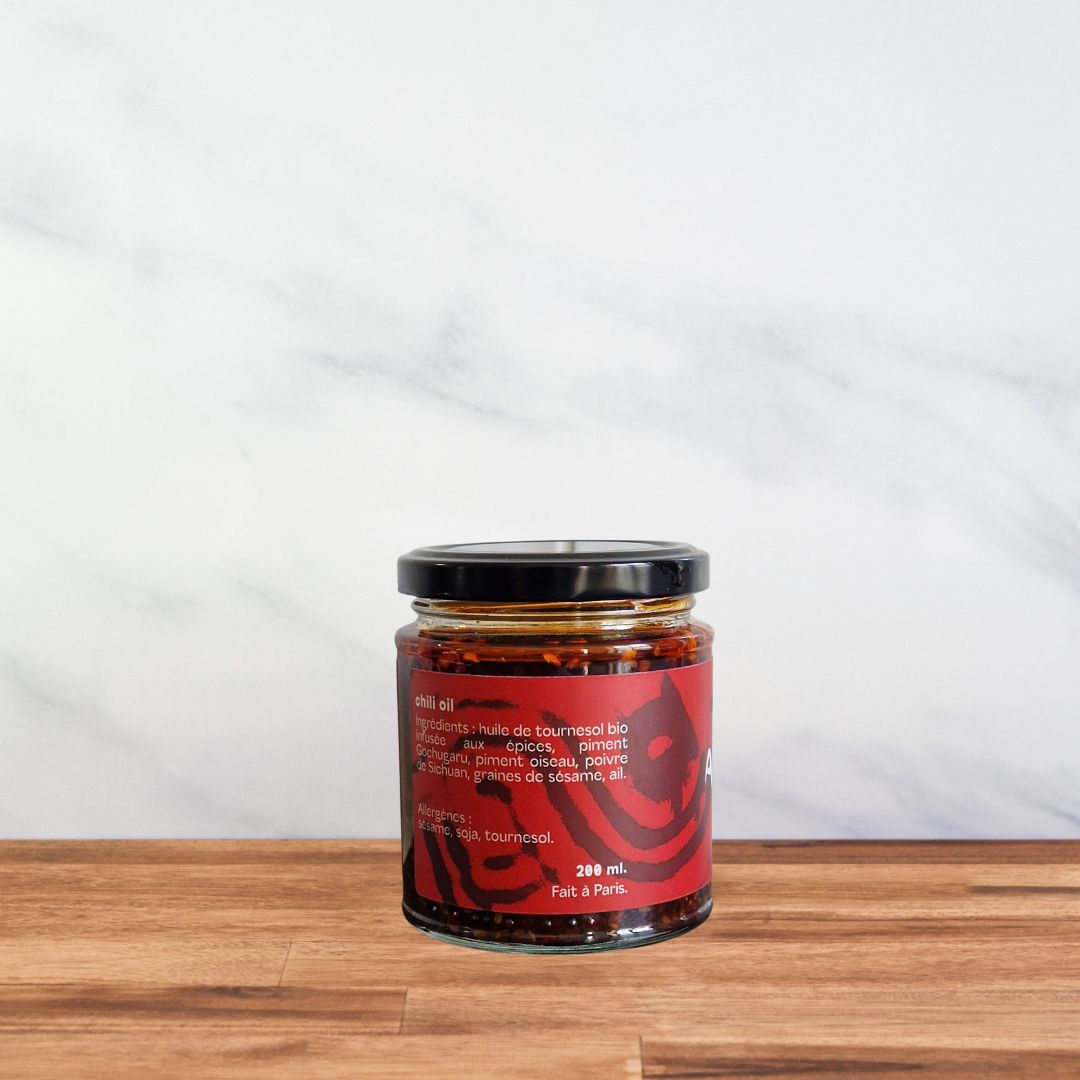Bocal en verre d’huile piquante Aïe Aïe Aïe au gochugaru coréen, un condiment artisanal aux épices et au poivre du Sichuan. Etiquette à l'arrière.