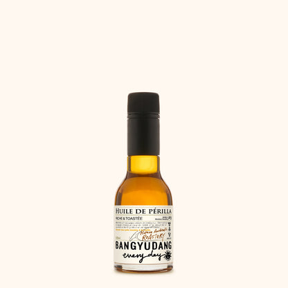 Bouteille de 100ml d'huile de périlla torréfiée Bangyudang P3, fond clair, étiquette beige à motif floral et typographie noire.