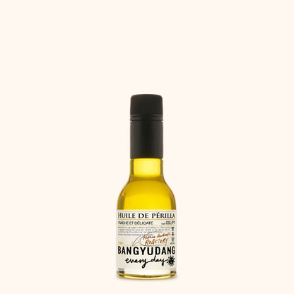 Bouteille de 100ml d'huile de périlla légère Bangyudang P1, fond clair, étiquette jaune pâle et typographie noire.