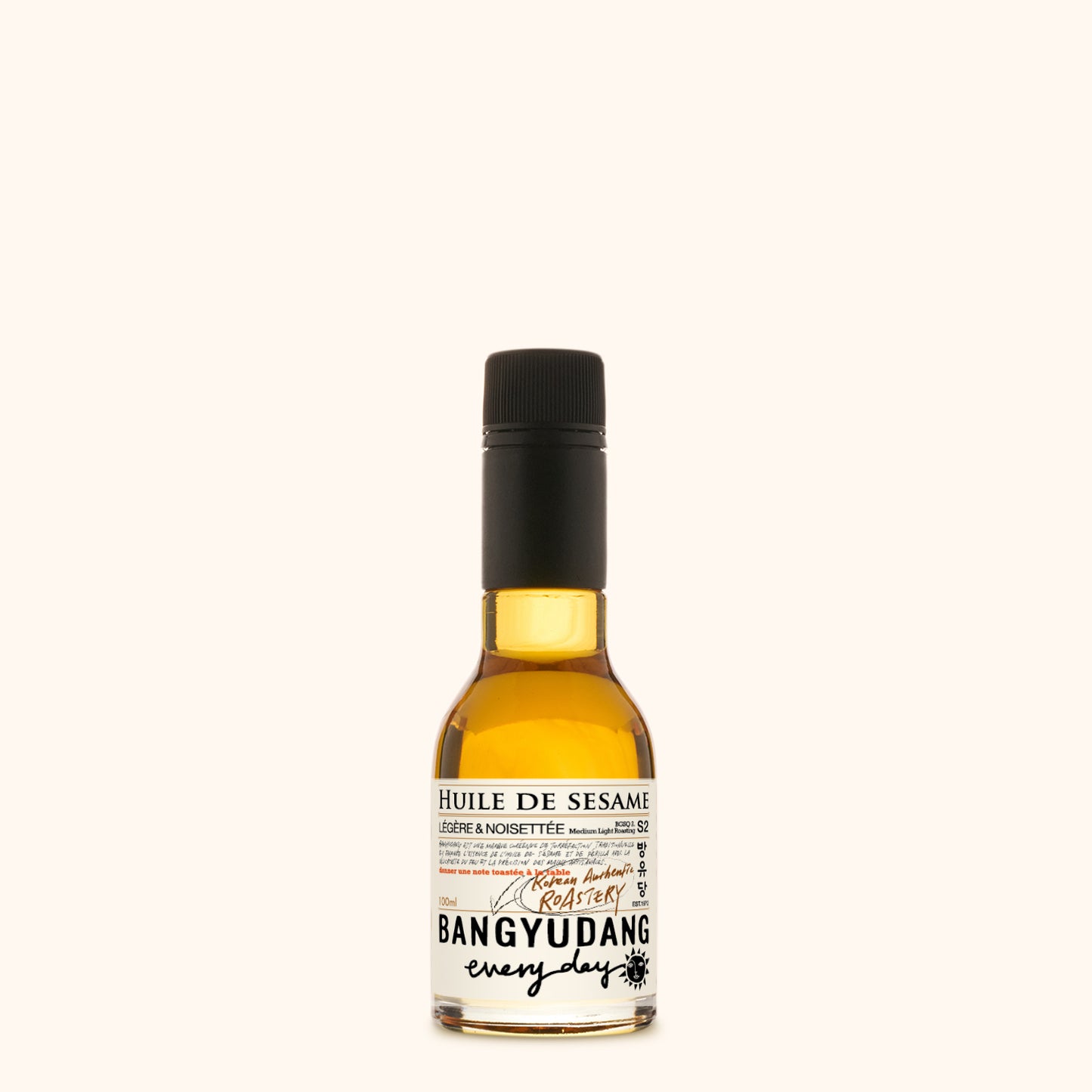 Bouteille de 100ml d'huile de sésame douce Bangyudang S2, fond clair, étiquette beige dorée et typographie noire.
