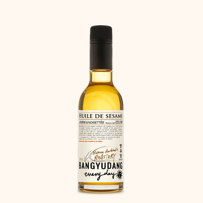 Bouteille de 200ml d'huile de sésame douce Bangyudang S2, fond clair, étiquette beige dorée et typographie noire.